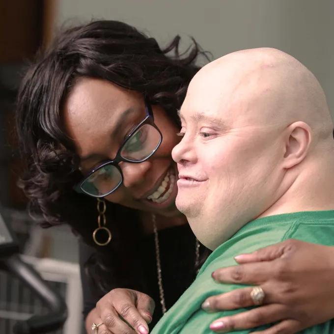 Caregiver with patient at exercise equipment.