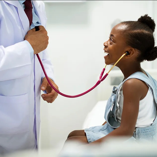 Little girl listening to a doctor's heart using a stethoscope